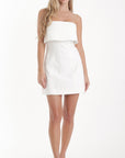 Woman wearing a white strapless dress on a white background