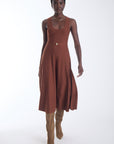 Ariene knit midi dress in copper cedar with a gold buckle self belt, worn with tan knee high boots, front view on model.