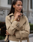 Woman wearing a beige trench coat in an urban setting