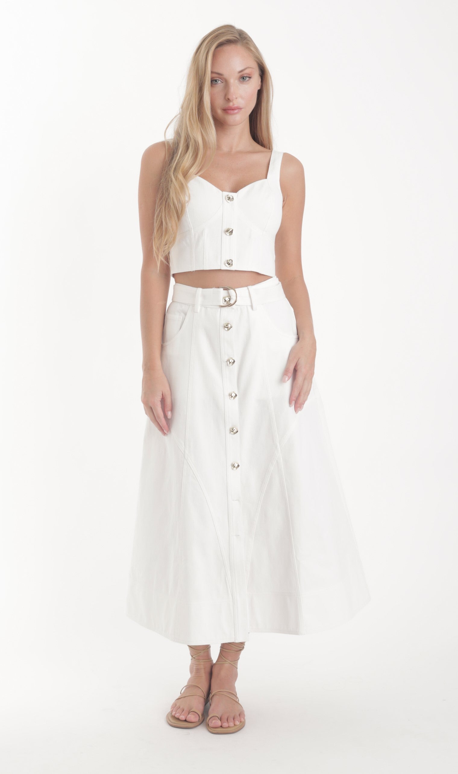 Woman wearing a white button-up top and skirt on a white background