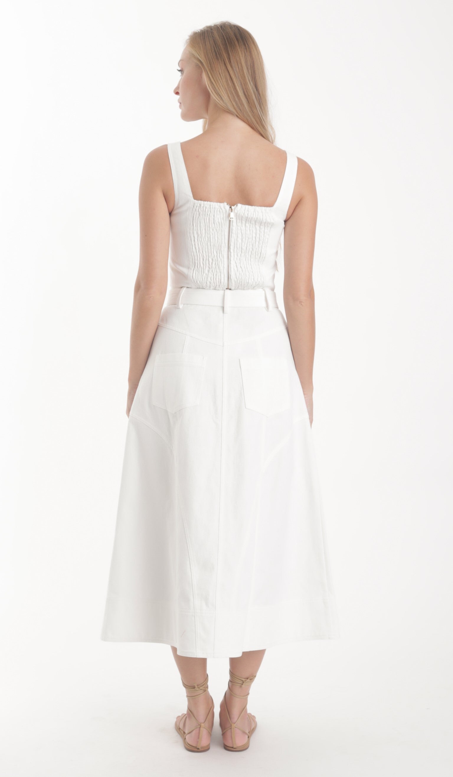 Woman wearing a white dress with thin straps on a white background