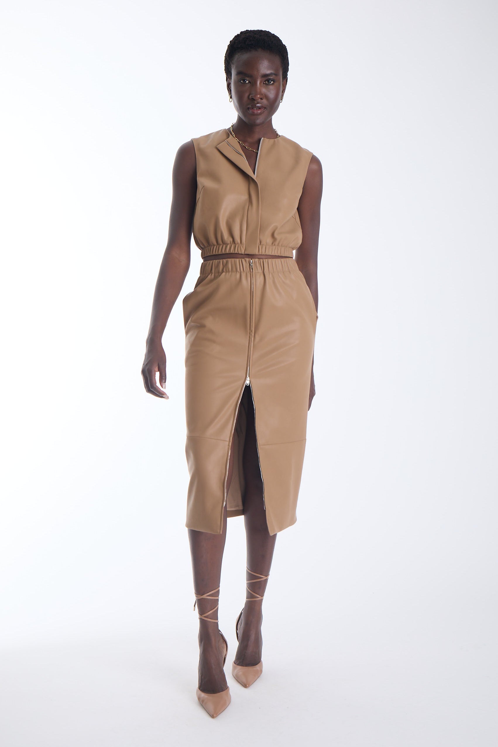 Enzo vegan leather midi skirt in camel with a full length gold front zip, front view on model.
