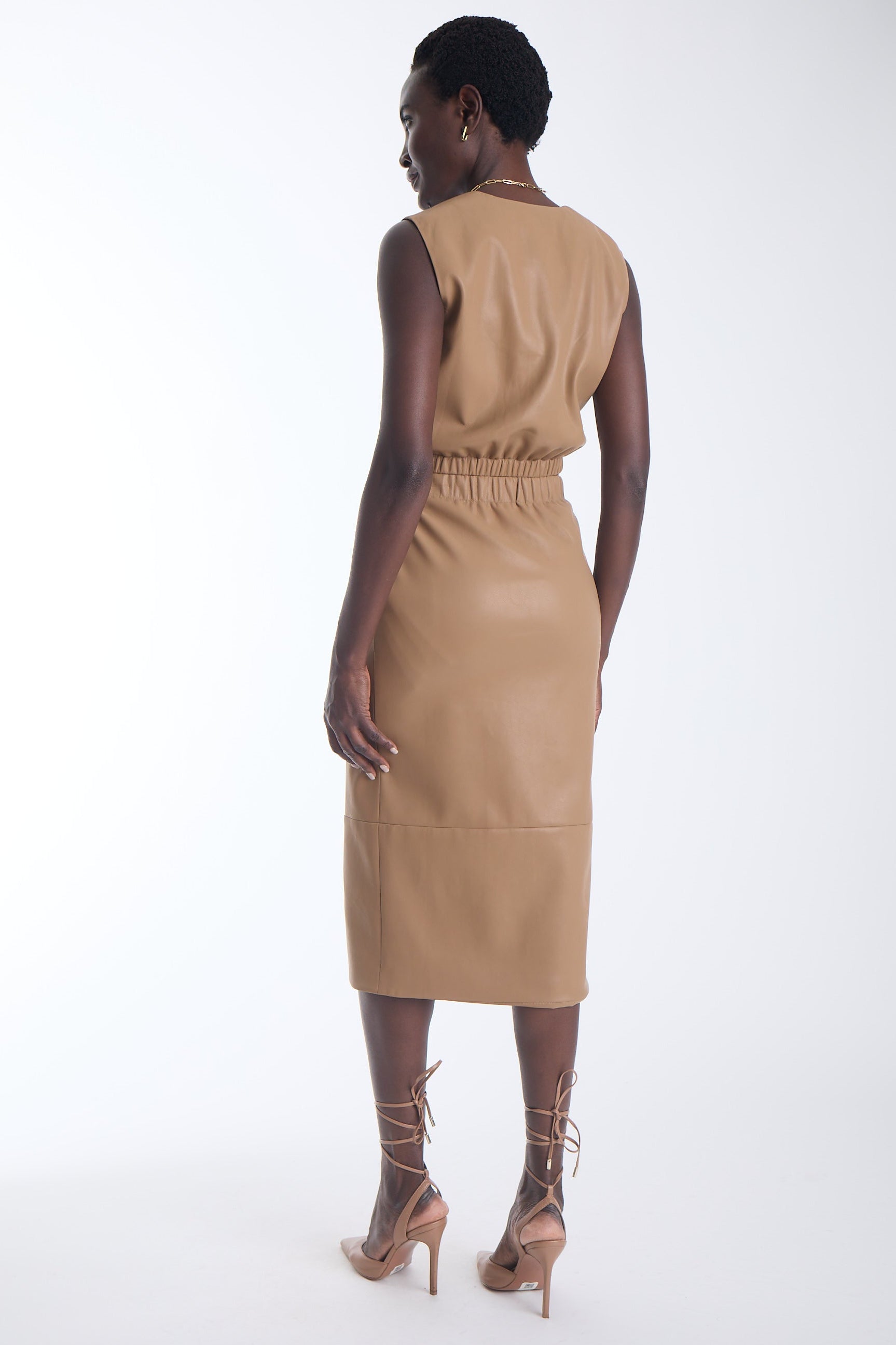 Enzo vegan leather midi skirt in camel showing the flared hem panel, back view on model.