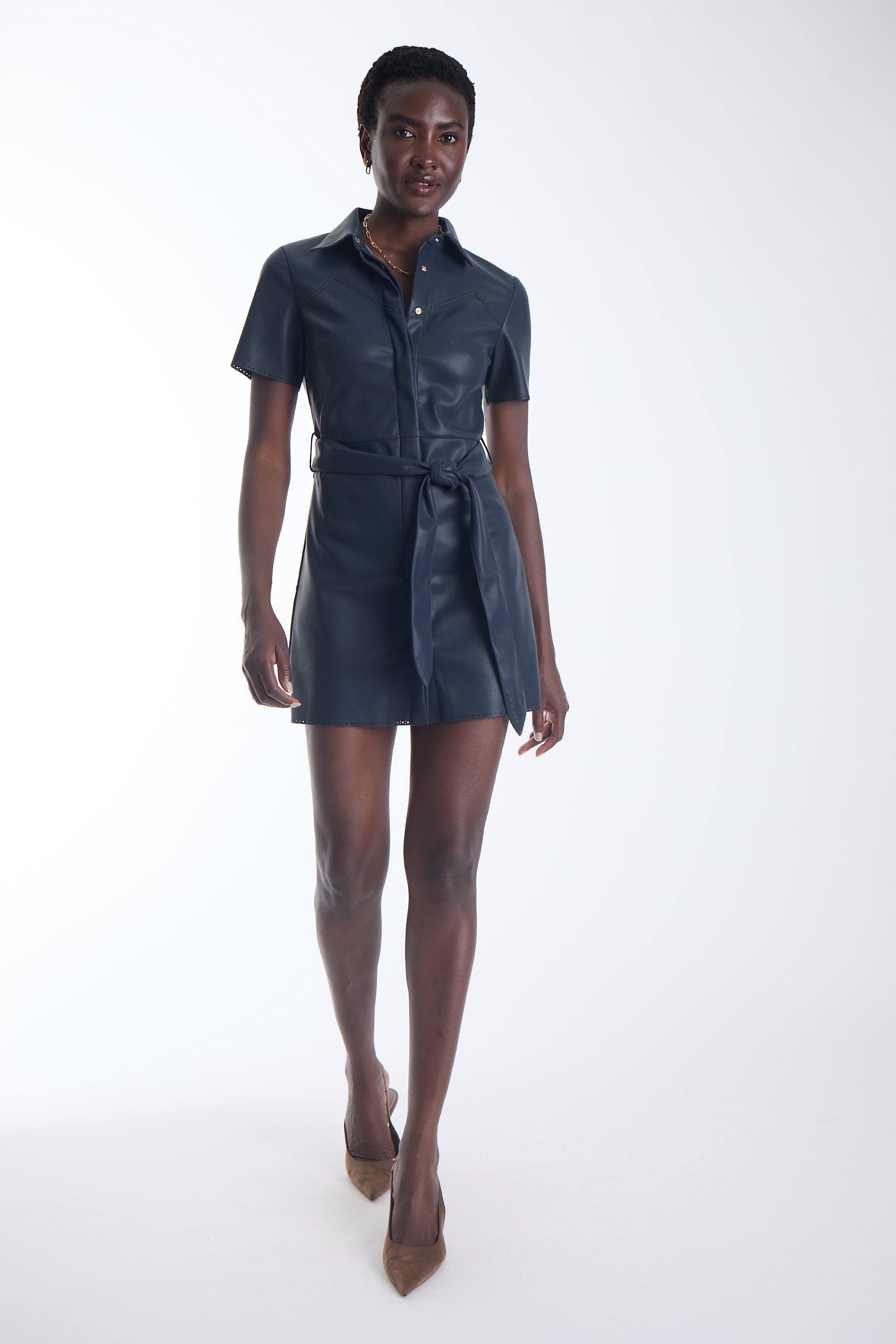 Mallie vegan leather mini shirtdress in navy with a self tie belt, front view on model.