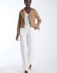 Vida cropped vegan leather trench jacket in camel with a notched lapel and self belt, worn open, front view on model.