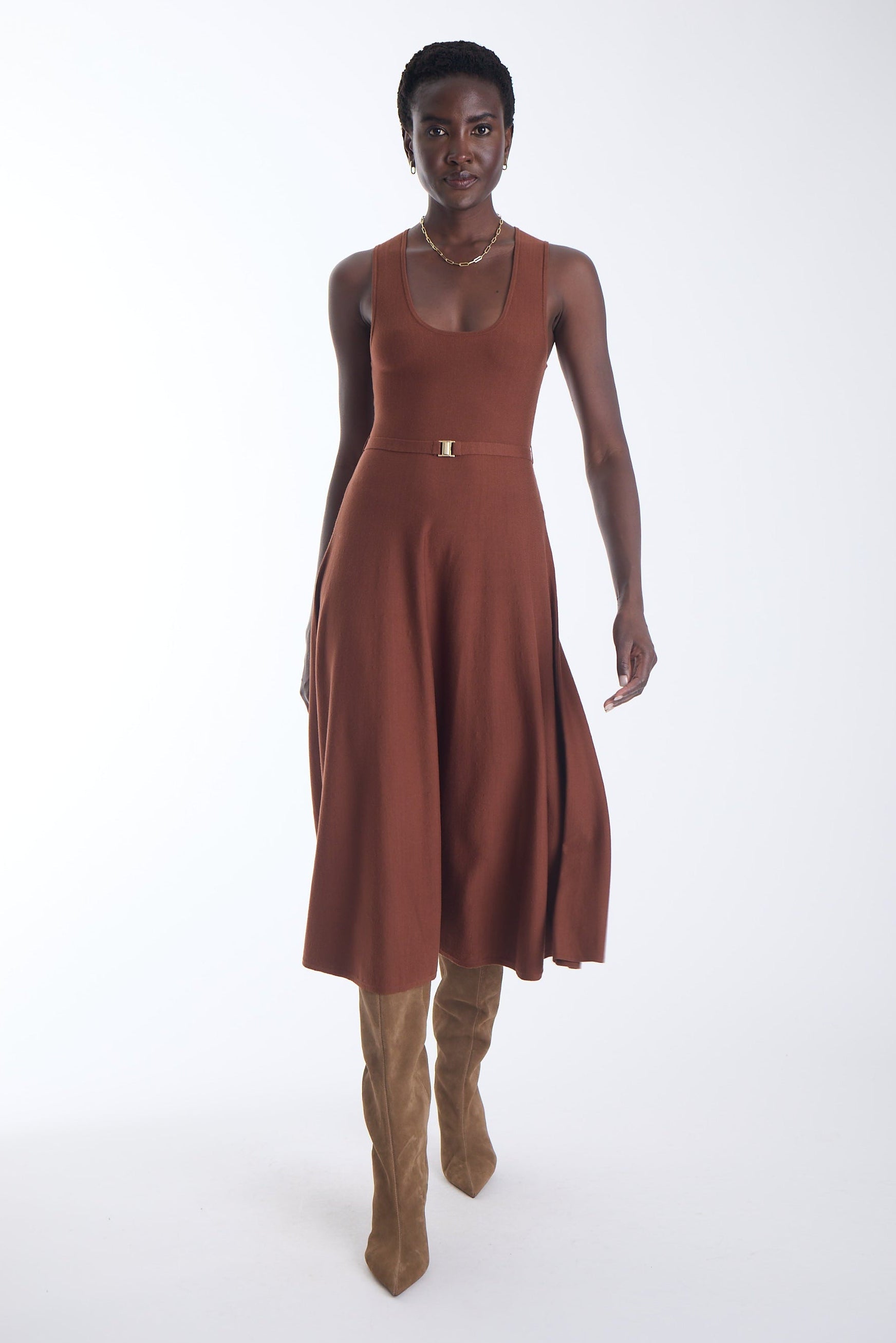 Ariene knit midi dress in copper cedar with a gold buckle self belt, worn with tan knee high boots, front view on model.