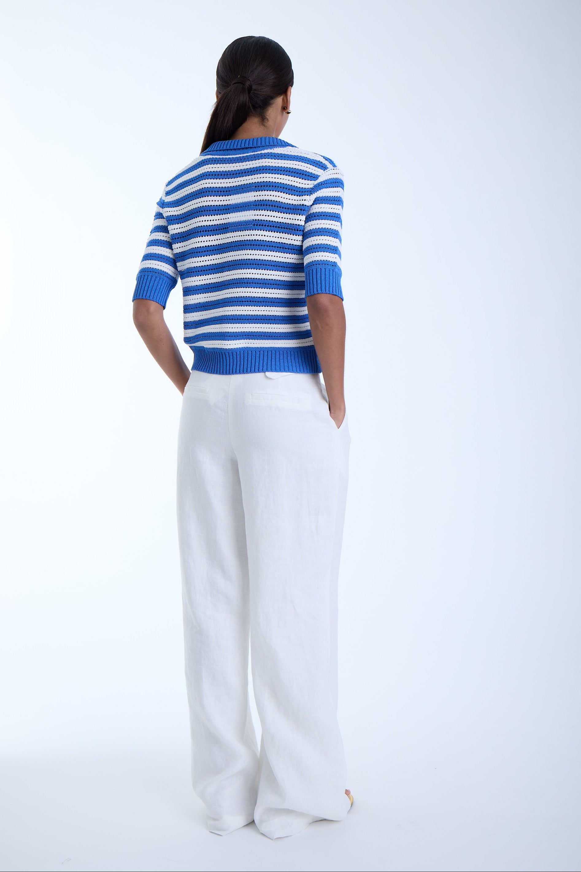 Woman wearing a beautiful blue and white stripped shirt on a white background