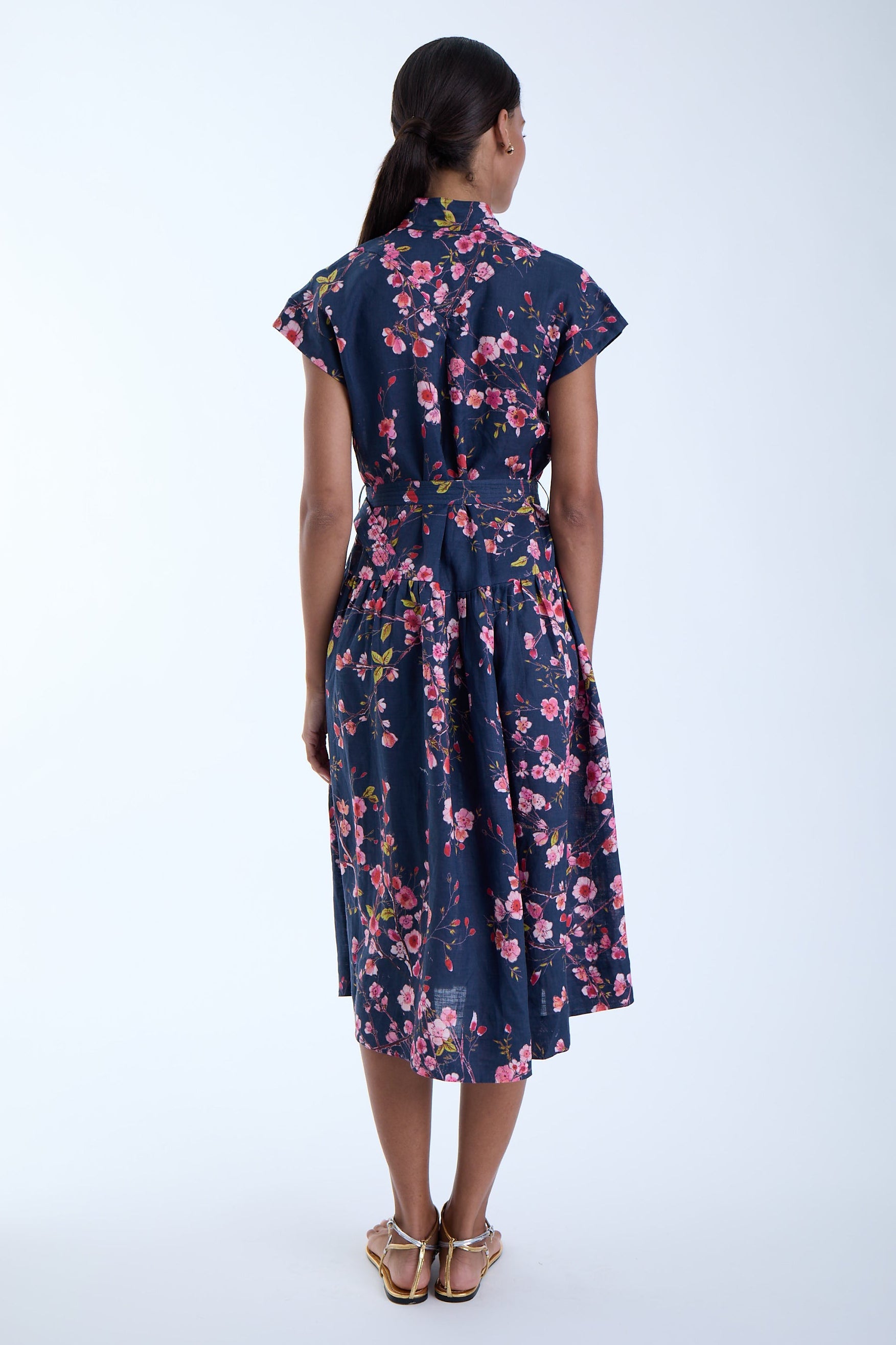 Model wearing a beautiful floral print dress with a white background 