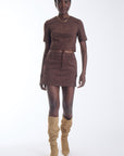 Karina Grimaldi Aria Suede Skirt in chocolate brown, front view on model, mini length with belt loops and a front button