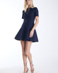 Karina Grimaldi Elsa Knit Mini Dress in navy, front view on model, polo collar and short sleeves with a slim belted waist and a flared skirt.