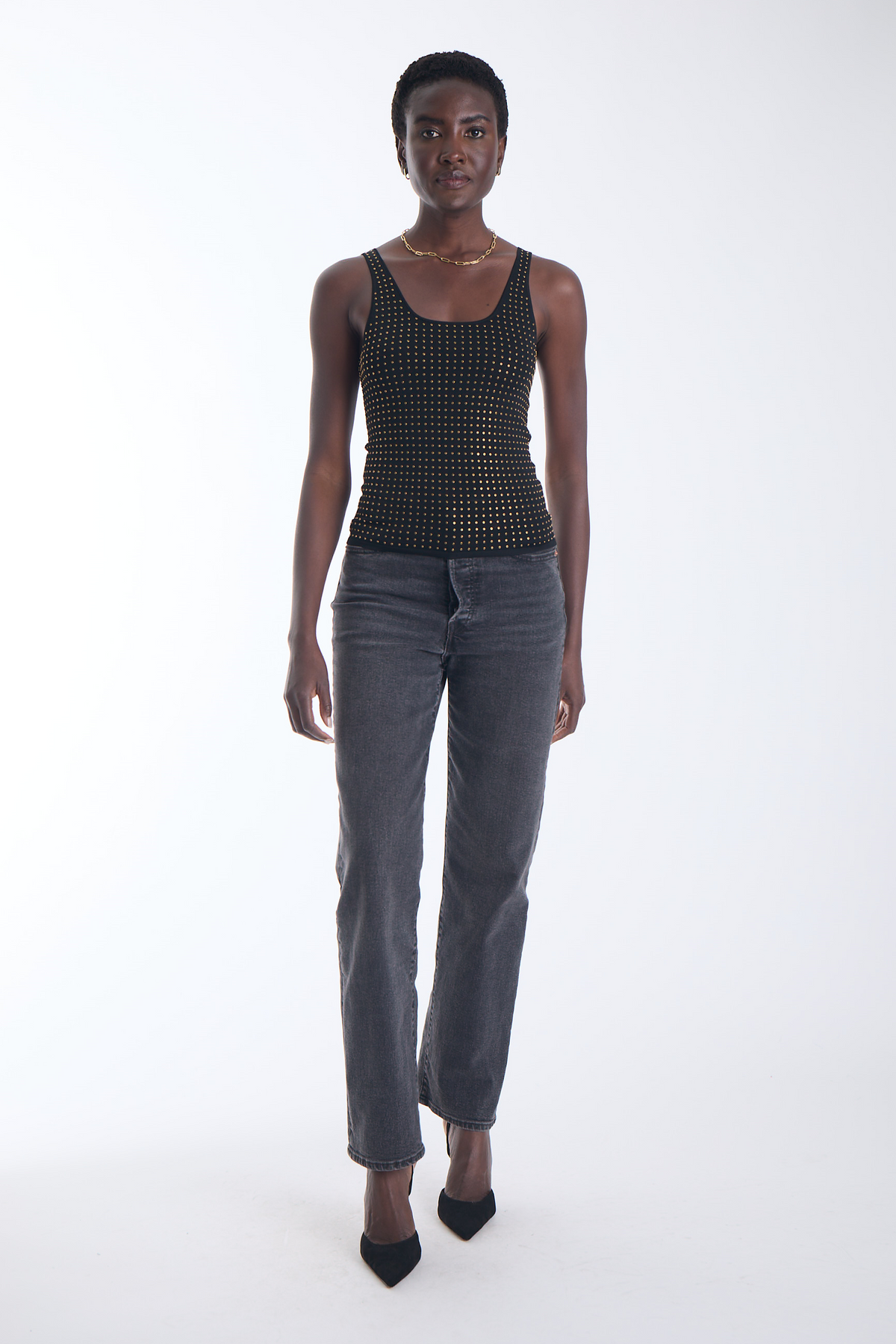 Karina Grimaldi Bowie Embellished Knit Tank in black, front view on model, scoop neck with allover gold studs, worn with jeans