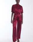 Karina Grimaldi Thea Pants in mulberry, front view on model, satin, high waisted and wide leg, worn with the Thea Blouse